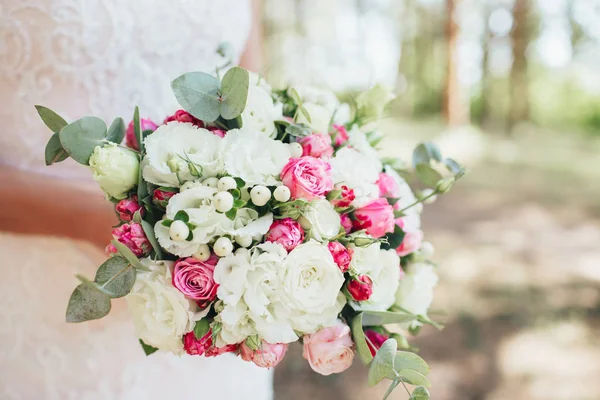 Buquê de casamento de rosas nas mãos da noiva. — Fotografia de Stock