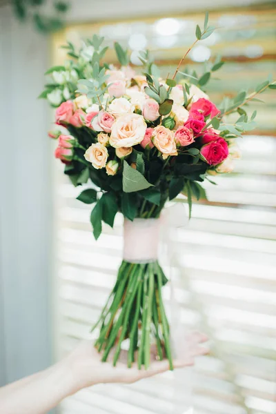Buquê de casamento de rosas nas mãos da noiva. — Fotografia de Stock