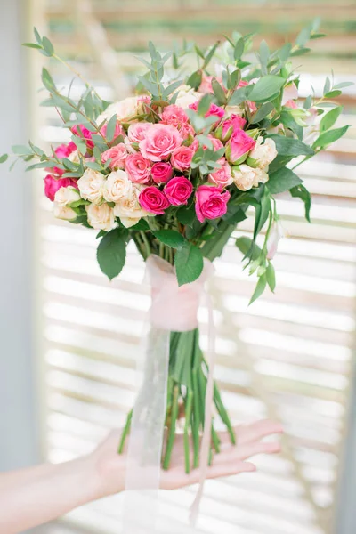 Buquê de casamento de rosas nas mãos da noiva. — Fotografia de Stock