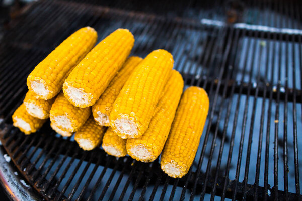 Органическая жареная кукуруза на початке, готовая к еде. Жареная кукуруза с тайским маслом. Жареные кукурузные початки на решетке
.