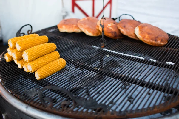 Organic Grilled Corn on the Cob Ready to Eat. Grilled corn with thai butter. Fried corncobs on a grid. Breaded cakes baked on the grill in winter.