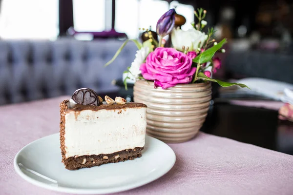 Çikolata kurabiye ve kremalı bisküvi ile krem peynirli kek. Oreo pasta ve masaya çiçek ile güzel bir vazo. Güzel bir buket çiçek gül ve Lale. — Stok fotoğraf