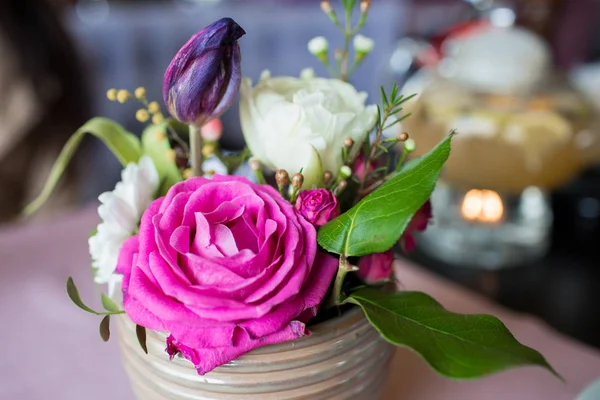 Pink flowers in a vase. A beautiful bouquet in a beige vase on the table. Beautiful design of the table in the cafe-restaurant. — Stock Photo, Image
