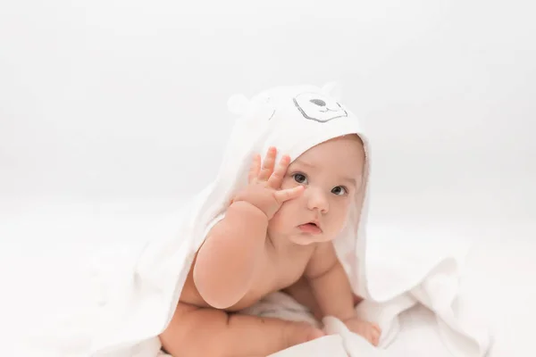 Leuke baby onder een roze handdoek met een capuchon na een bad. Baby in een handdoek. Kinderportret. Gezondheidszorgconcept. — Stockfoto