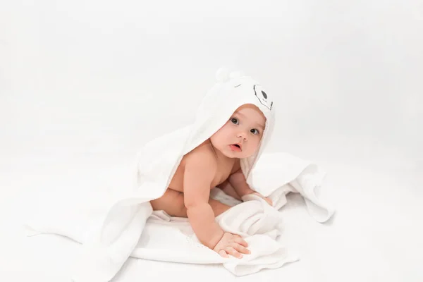 Cute baby under a pink towel with a hood after a bath. Baby in a towel. Children's portrait. Healthcare concept. — 스톡 사진