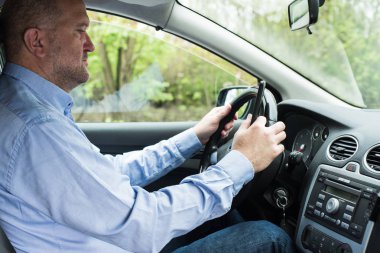 Araba kullanırken telefonu kullanan adam