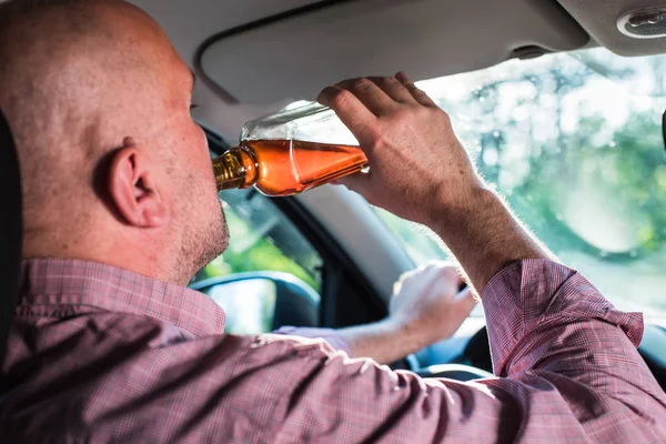 Homme buvant de l'alcool dans la voiture . — Photo