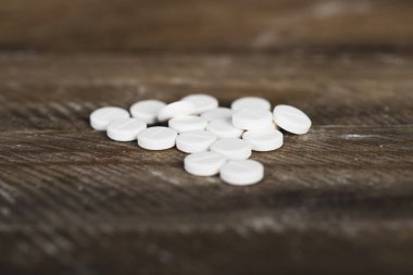 Ahşap arka plan üzerinde beyaz ilaçlar.