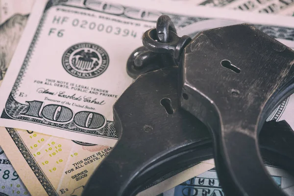 Dollars and handcuffs. Financial crime, illegal activity