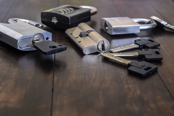 A new lock with keys on a wooden table. — Stock Photo, Image