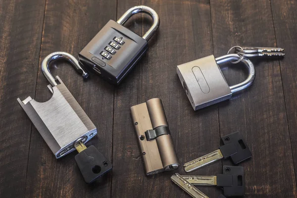 A new lock with keys on a wooden table. — Stock Photo, Image