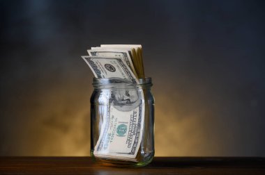 Cam bir kavanozda 100 dolarlık banknotlar.