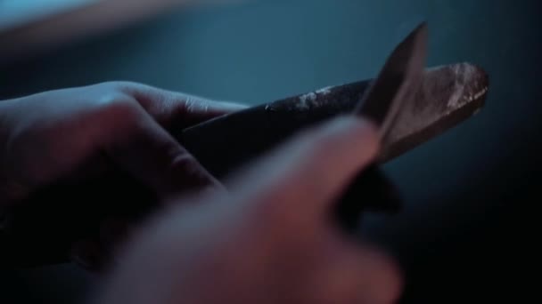 A man is sharpening a knife on a grindstone close-up. — Stock Video