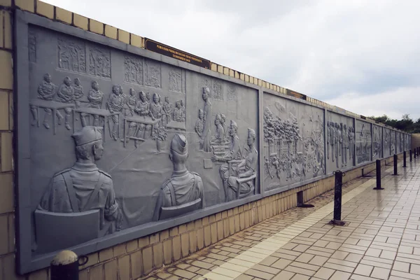 sculpture wall that tells the story of a hero