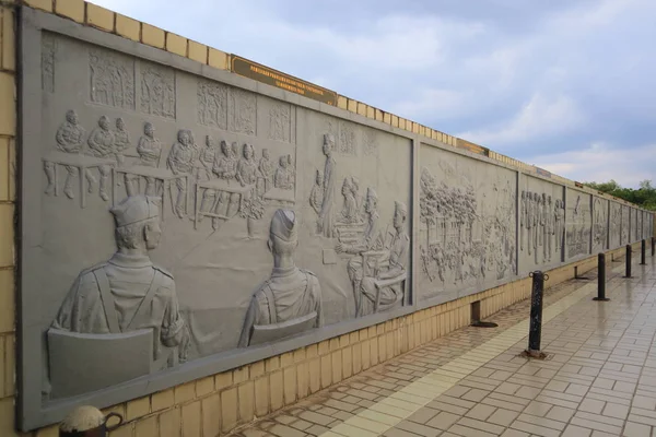 sculpture wall that tells the story of a hero