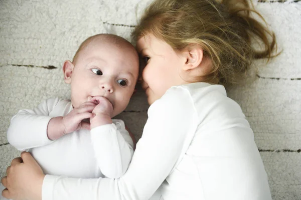 Hermana chica abraza recién nacido hermano —  Fotos de Stock