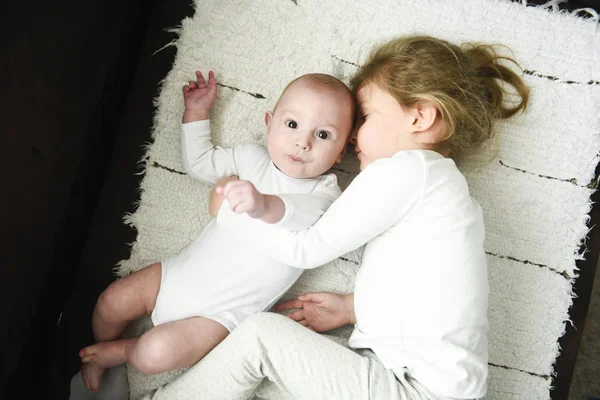 Schwester umarmt neugeborenen Bruder — Stockfoto