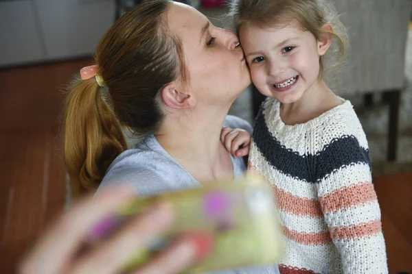 Young mother makes selfie photo with daugther