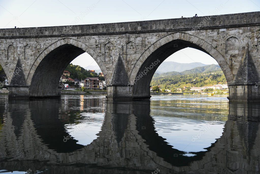 The Ottoman Mehmed Pasa Sokolovic Bridge over Drina river in Visegrad, Bosnian mountains, with fantastic  river reflection. Bosnia and Herzegovina.