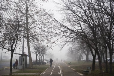 BELGRAD, SERBIA - 16 Ocak 2020: Sokaklarda yürüyen insanlar, yoğun sis nedeniyle Sırp başkenti üzerinde gökyüzüne hakim. Birkaç gündür şehirde yoğun bir kirlilik bulutu görülüyor.