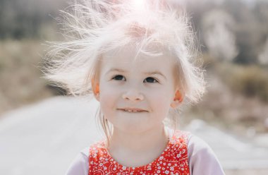 Dışarıda gülümseyen küçük kızın portresi, mutluluk konsepti ve dikkatsiz çocukluk.