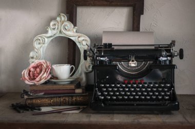 Natürmort ev iç ayrıntıları. Vintage kız ahşap çerçeve, fincan kahve, paeony, daktilo, kitap, mektup, beyaz tüy, kalem rustik tarzı ahşap arka plan üzerinde