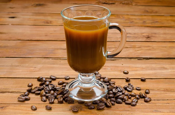 Deliciosos granos de café y café sobre una mesa de madera . —  Fotos de Stock