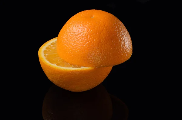 Narancs vágott két darab, a fekete háttér. — Stock Fotó