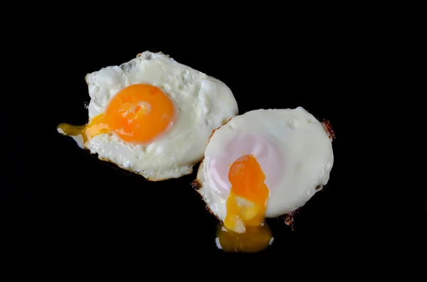 Жареные яйца закрываются на черном фоне . — стоковое фото