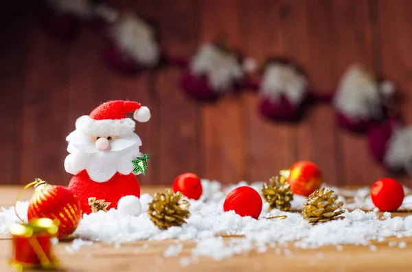Zabawka Santa Claus i Świąteczne ozdoby na starym drewnianym stole — Zdjęcie stockowe
