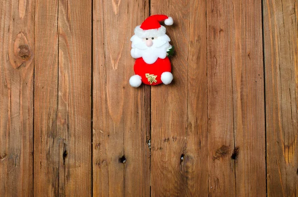 Santa figurku na dřevěné pozadí, Vánoční dekorace. — Stock fotografie