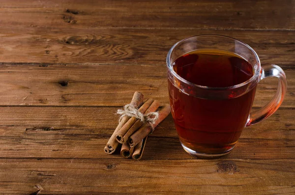 Taza de té y canela sobre fondo de madera . — Foto de Stock