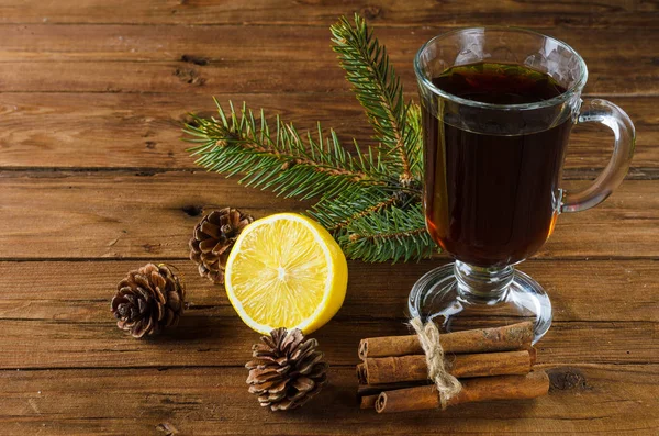 Heißer Tee mit Weihnachtsdekoration, auf einem Holztisch. — Stockfoto