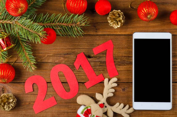 Smartphone ve Noel dekorasyon ahşap bir masa üzerinde. — Stok fotoğraf