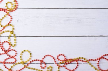 Beyaz ahşap bir masa üzerinde Noel süsleme, kırmızı ve altın boncuk.