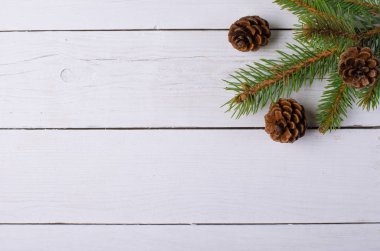 Noel ağacı ve koniler Beyaz ahşap zemin üzerinde.