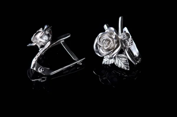 Silver earrings in the form of a rose isolated on a black backgr — Stock Photo, Image