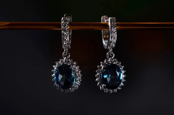 Silver earrings with blue topaz isolated on a black background. — Stock Photo, Image