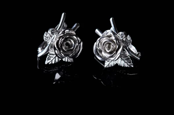 Silver earrings in the form of a rose isolated on a black backgr — Stock Photo, Image