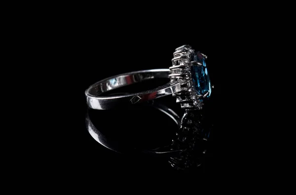 Silver ring with blue topaz isolated on a black background. — Stock Photo, Image