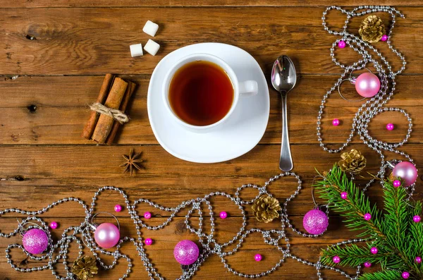 Weihnachtsdekoration und eine Tasse heißen Tee auf einem Holztisch. — Stockfoto