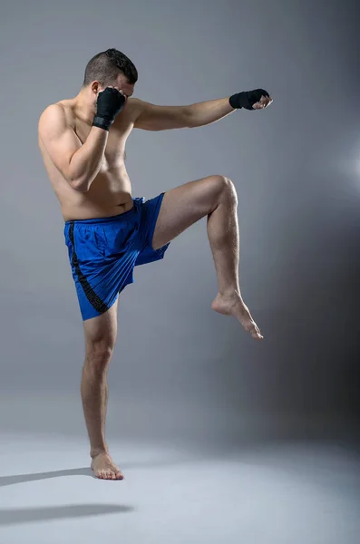 Portret kick-boxer na szarym tle. — Zdjęcie stockowe