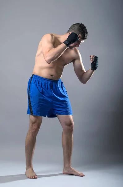 Portrét kickboxer na šedém pozadí. — Stock fotografie