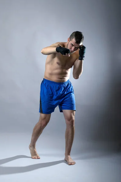 Portrait of kickboxer on a gray background. — Stock Photo, Image