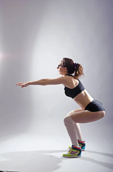 체육 여자 crouches, 회색 배경 사진. — 스톡 사진