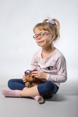 gri bir arka plan üzerinde bir oyuncak ayı ile güzel kız.