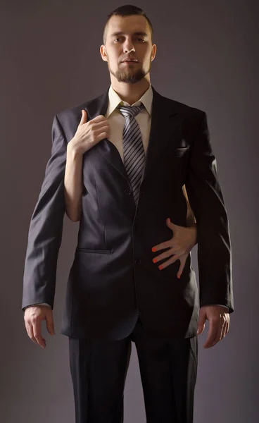 Стильний чоловік в костюмі і краватка на сірому фоні . — стокове фото