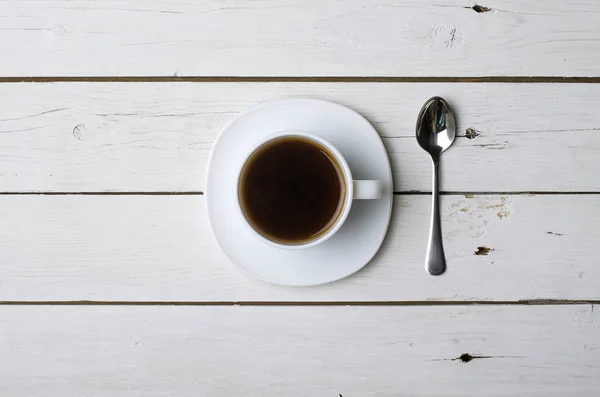 Чашка горячего кофе на белом деревянном столе, вид сверху . — стоковое фото