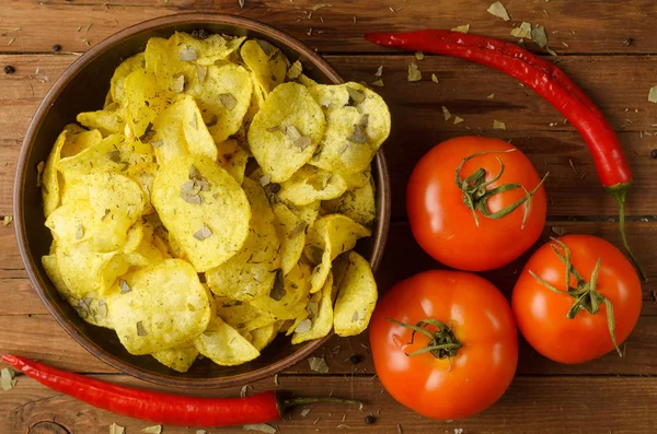 Appetizing composition: potato chips, tomato and chili peppers o — Stock Photo, Image