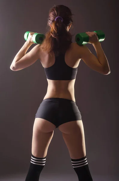 Sport giovane donna con manubri, vista posteriore . — Foto Stock